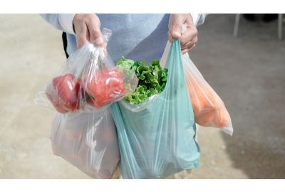 Image of person carrying shopping in a plastic bag.
