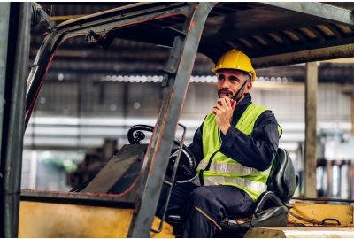 Man driving a forklift in a warehouse.