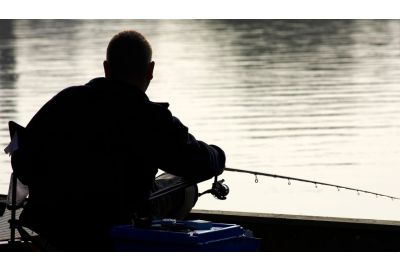 Man fishing on a river bank.