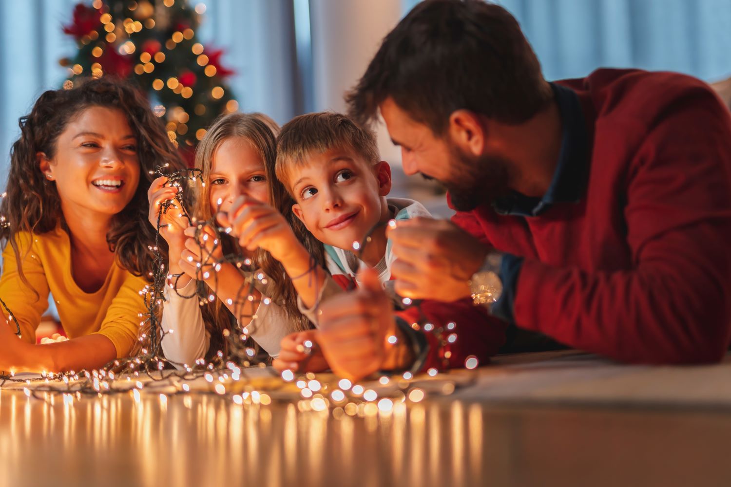 Family untangling Christmas lights.