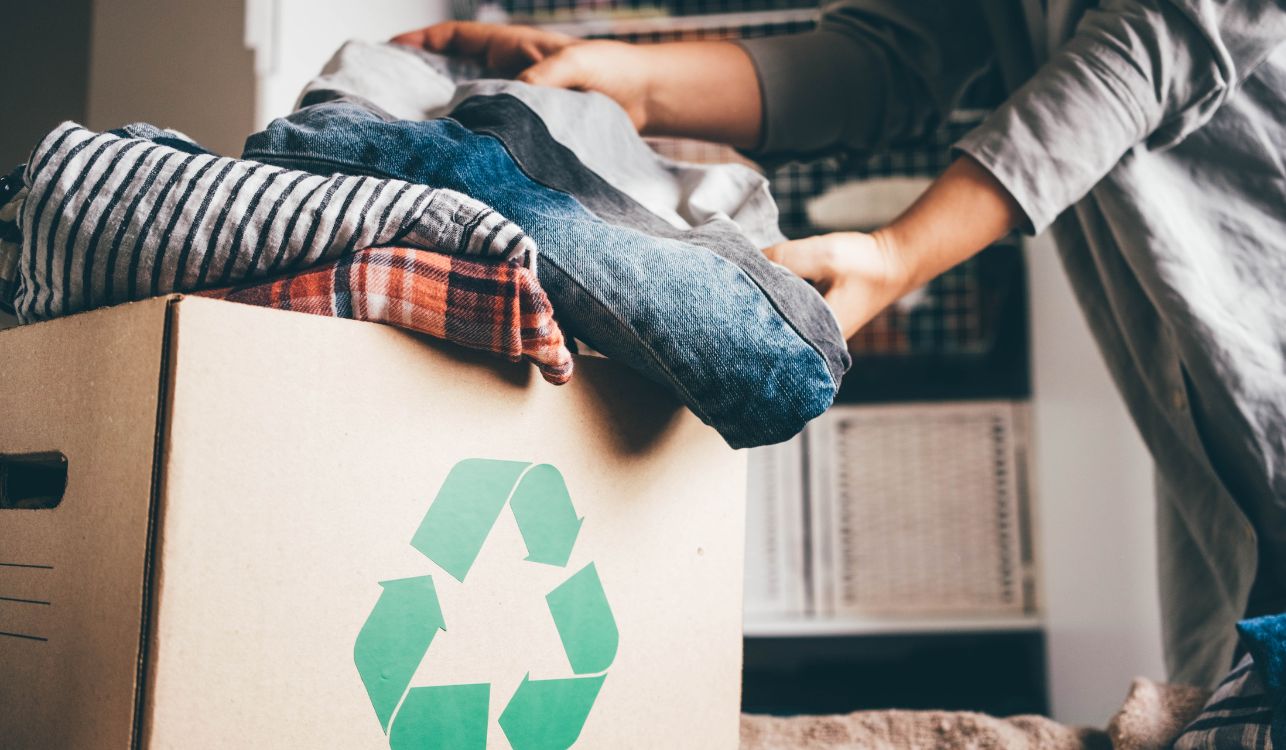 Image of woman loading clothes into a cardboard box.