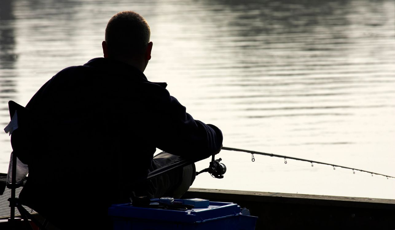 Man fishing on a river bank.