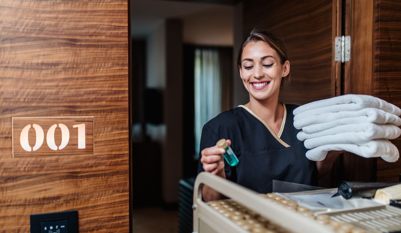 Image of women cleaner leaving hotel room. 